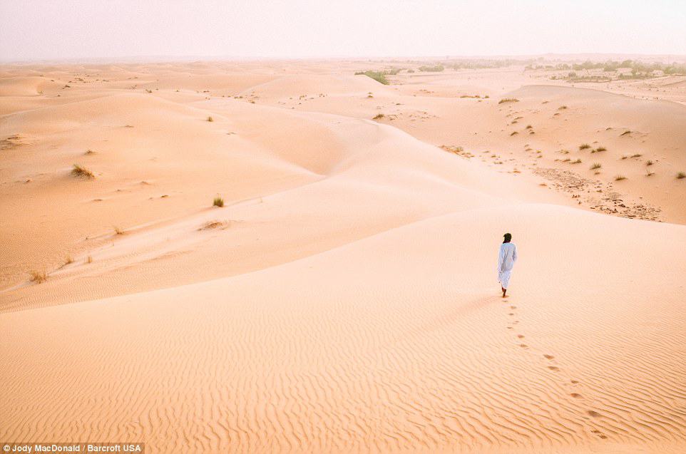 A Mauritanian man walking into the vastness of the Sahara desert